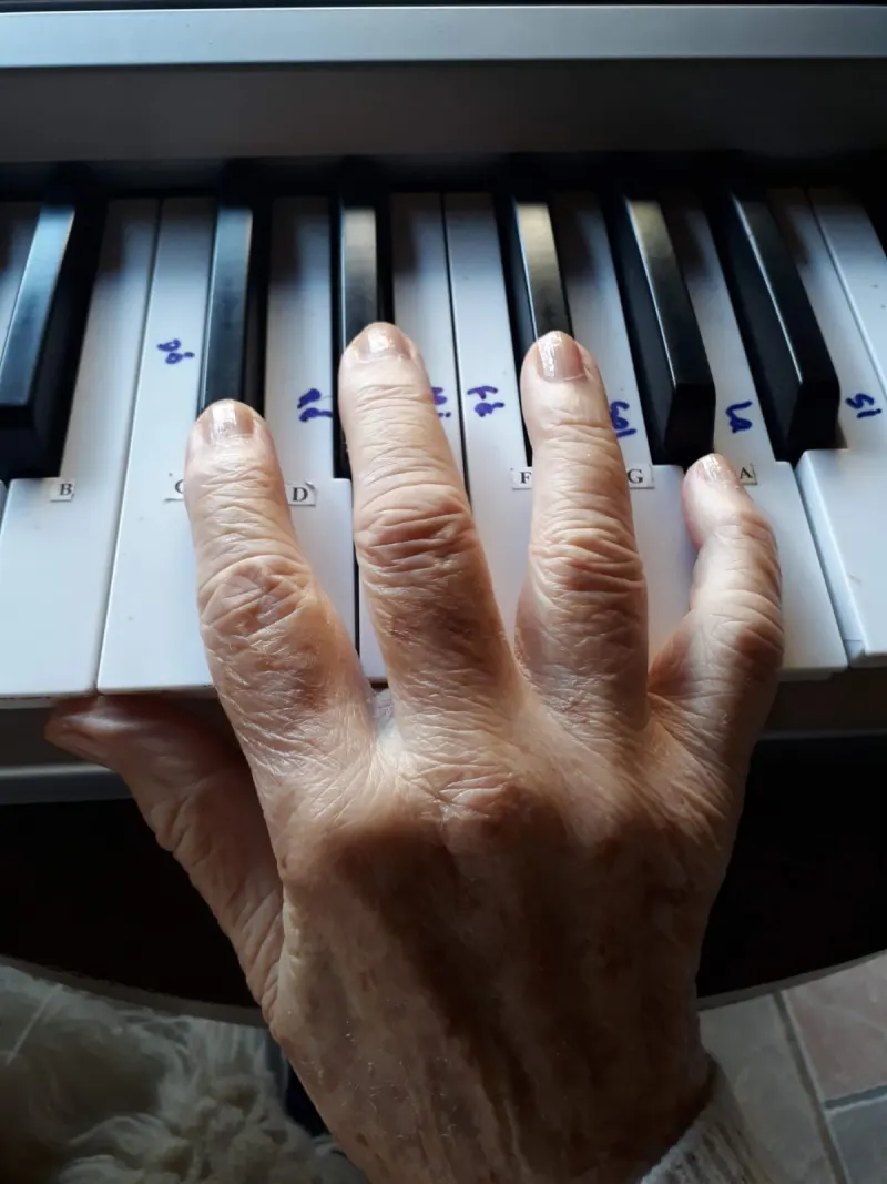 Paciente da Ágape & Luz em estimulação cognitiva com piano